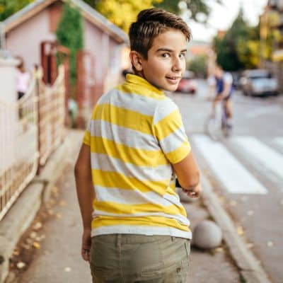 Niño caminando con un teléfono móvil sencillo Panasonic KX-TU410